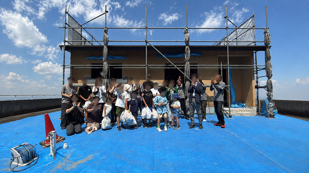 建物前での集合写真 高松市牟礼町の新築住宅の上棟式で記念撮影
